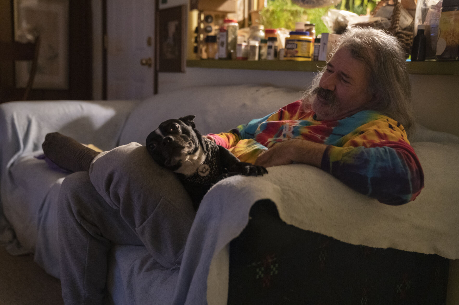 Robert Morrison pets his roommate's dog Lucky while watching a movie
